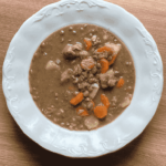 Tányérban tálalt, sűrű lencsegulyás sertéshússal és sárgarépával. Kiadós magyar egytálétel.