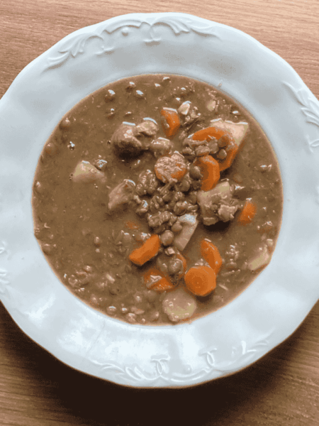 Tányérban tálalt, sűrű lencsegulyás sertéshússal és sárgarépával. Kiadós magyar egytálétel.