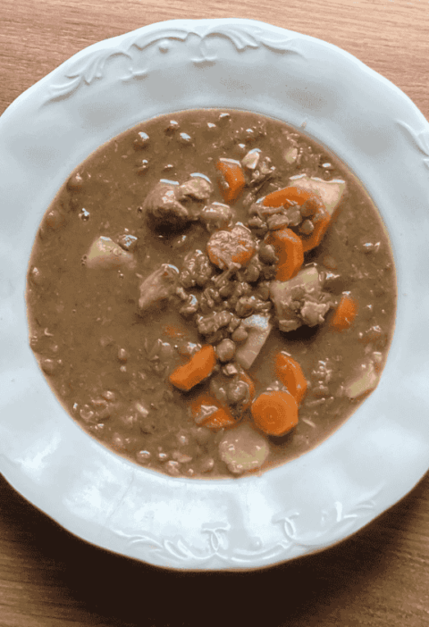 Tányérban tálalt, sűrű lencsegulyás sertéshússal és sárgarépával. Kiadós magyar egytálétel.